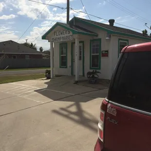 a red car parked in front of a building