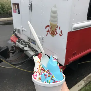 a hand holding a cup of ice cream
