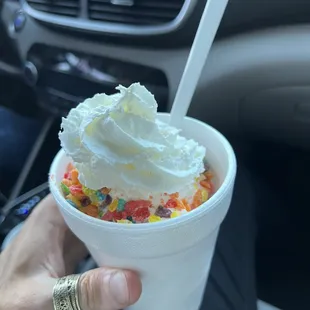 a hand holding a cup of ice cream