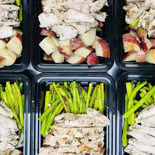 a tray of chicken, potatoes, and asparagus