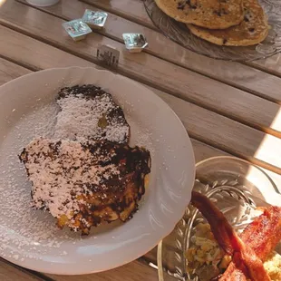 a breakfast of pancakes, bacon and eggs