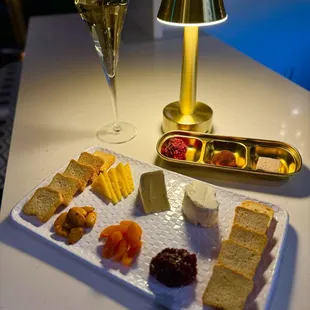 a platter of cheese, crackers, and fruit