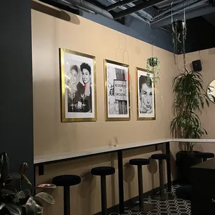 a row of bar stools and a row of framed pictures