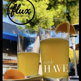 two glasses of beer and an orange