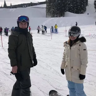 a man and a woman on a snowboard
