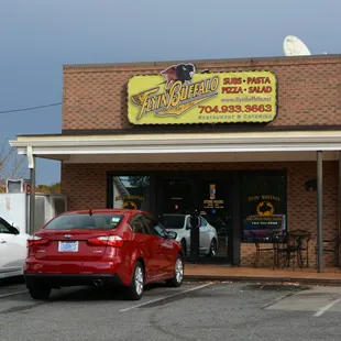 two cars parked in front of a restaurant