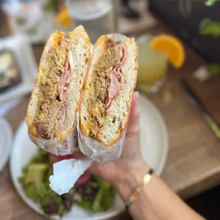 a person holding a sandwich