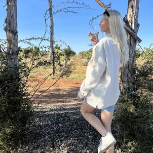 a woman standing in front of a pergolated arbor
