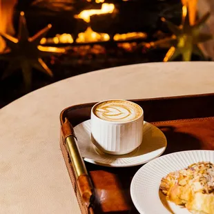 a cup of coffee and a pastry on a tray