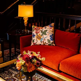 a living room with a red couch and coffee table