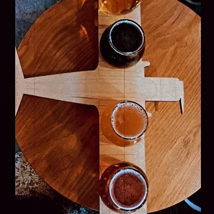 a flight of beers on a wooden table