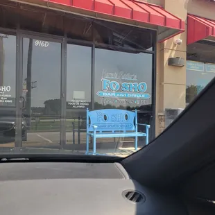 a blue bench in front of a restaurant