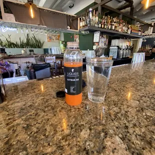 a glass of water and a bottle on a counter