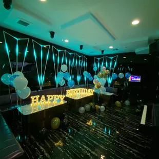 a party room with balloons and a piano