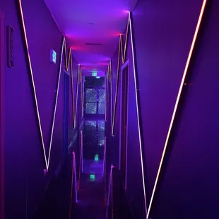 a long corridor with neon lights