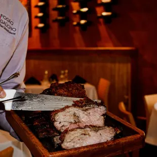 a man cutting meat on a cutting board