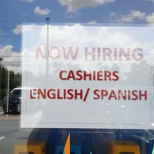 a sign that says now hiring cashers english / spanish