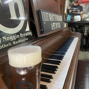 a pint of beer next to a piano