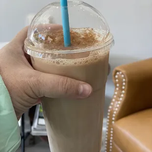 a hand holding a cup of iced coffee