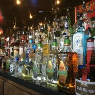 bottles of alcohol lined up on a bar