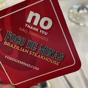 a hand holding a no thank card