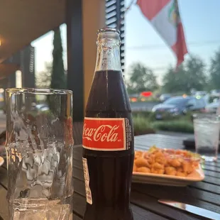 a glass of coke and a plate of food