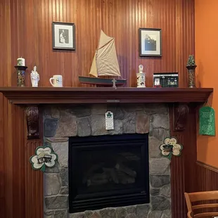a fireplace with a sailboat on top