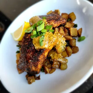 Blackened Mahi Mahi over herb roasted potatoes with creamy chipotle pesto sauce.