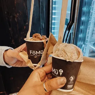 a hand holding a cup of ice cream