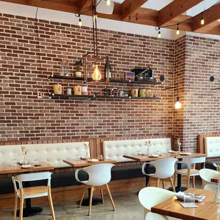 a restaurant with brick walls and white chairs