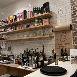 a bar counter with wine glasses and bottles on it