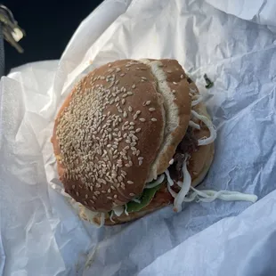 a hamburger with sesame seeds and lettuce