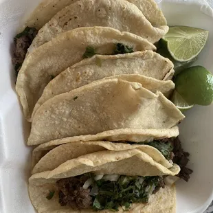 four tacos in a styrofoam container