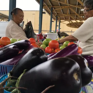 a man and a woman shopping for vegetables
