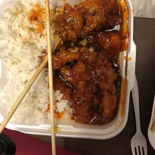 a takeout meal with rice and chopsticks