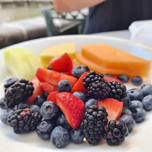 a plate of fruit and a melon
