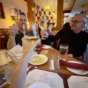 a group of people toasting wine glasses