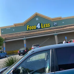 a car parked in front of a food 4 less store