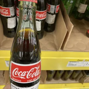 a hand holding a bottle of coca cola