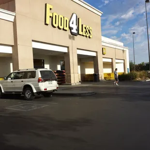 a car parked in front of a food 4 less store