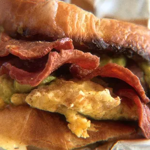extra toasted croissant breakfast sammi with turkey bacon, scrambled eggs, avocado and aged cheddar