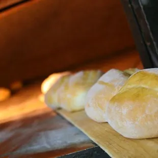 a row of bread rolls in an oven