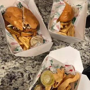 two sandwiches and french fries on a table