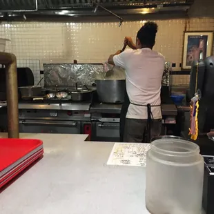 At the cash register- background shows one of the cooks stirring a BIG pot!