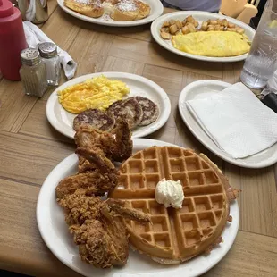 Chicken and waffles, turkey sausage, and eggs. French toasts and an omelette with home fries in the back