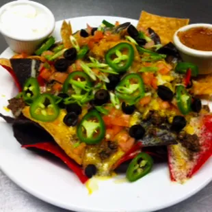 Beef Nachos - House-made tortilla chips with aged Wisconsin cheddar, black olives, diced tomatoes, jalapenos, and Angus ground beef