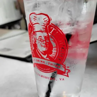 a glass of water with ice and a straw