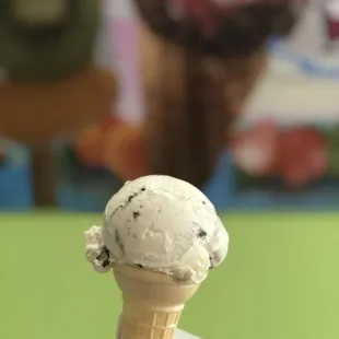 a hand holding a cone of ice cream