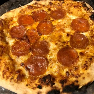 a pepperoni pizza on a pan