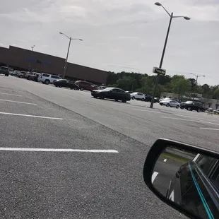 a view of a parking lot from a car&apos;s side mirror